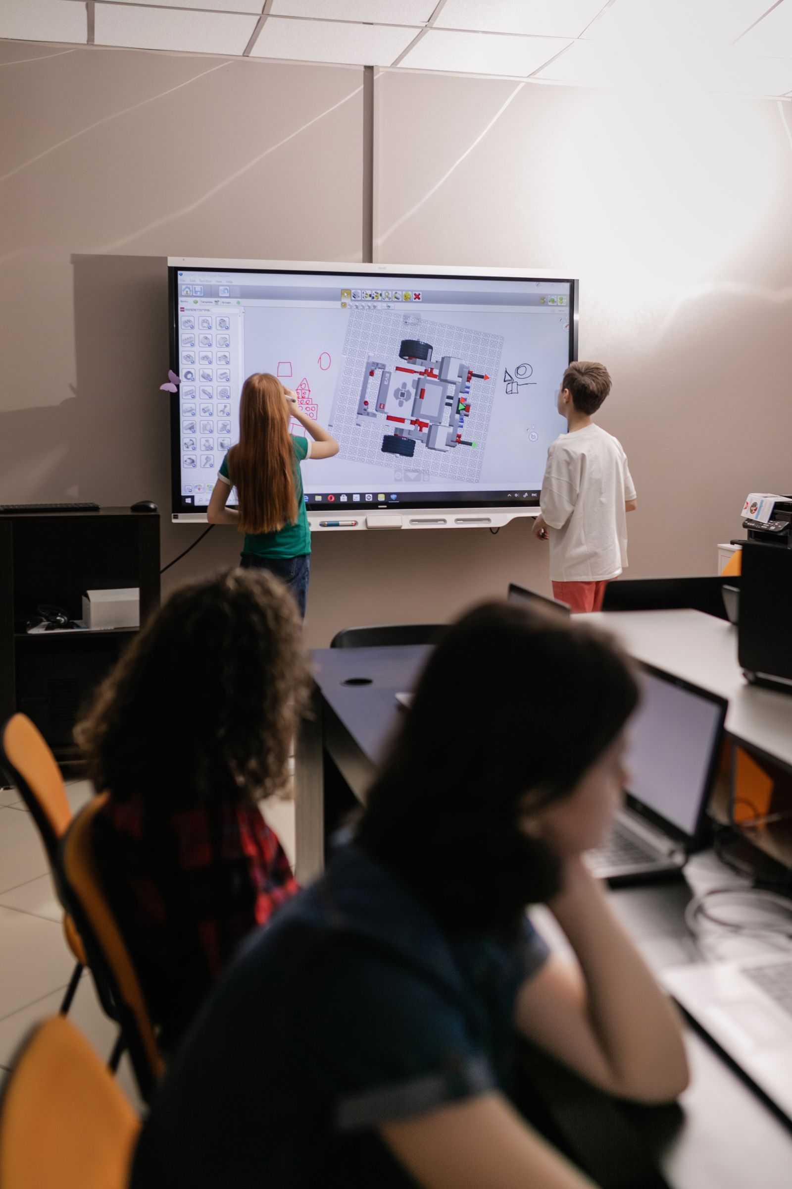 Students working together at an interactive touch panel during a robotics lesson